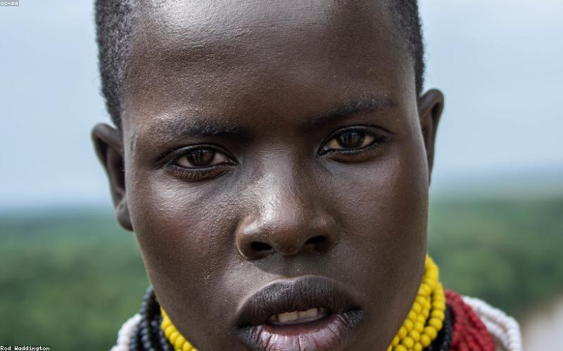 A glass of water with lemon slices next to a date palm and prayer beads