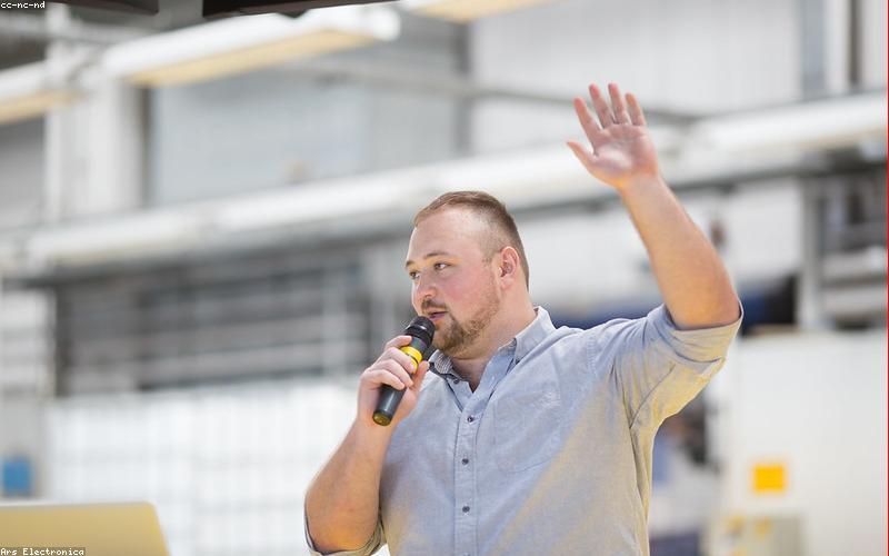 A busy street market in Lahore, Pakistan, with people walking around, many using their smartphones, depicting the omnipresence of mobile technology.