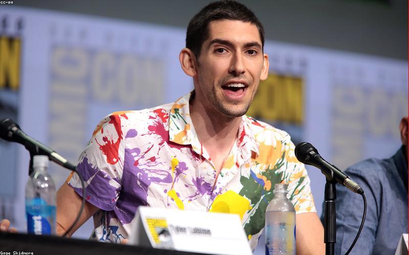 A person wearing light, loose cotton clothing, sitting comfortably in a shaded, cool area, perhaps fanning themselves gently.