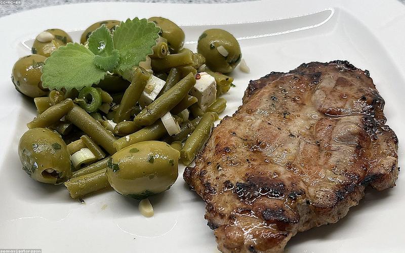 Chicken Karahi served in a traditional black karahi dish, surrounded by hot naan bread and a small bowl of fresh salad