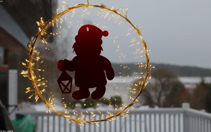 A group of young friends laughing and enjoying chai at a home chai dhabba setup, possibly on a rooftop or balcony, decorated with festive lights.