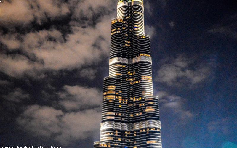 Someone happily using a smartphone to take a selfie in a bustling Pakistani market setting.