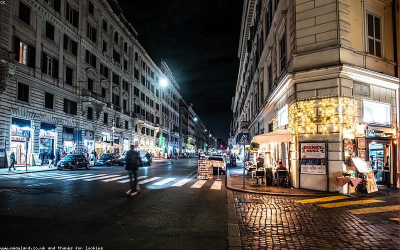 A beautifully styled platter of Halwa Puri, chanay, and achar on a rustic wooden table in a modern cafe setting.