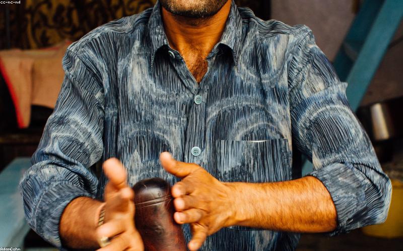 A close-up shot of a steaming bowl of Nihari, garnished with ginger, green chilies, and served with hot naan and a glass of lassi.