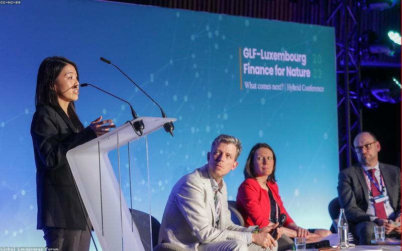 People in Pakistan reacting to news on their phones, looking concerned or discussing.