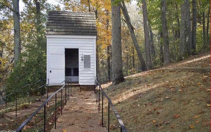 A person gently holding their head, looking tired or unwell, with a glass of water nearby, implying the need to break fast if necessary