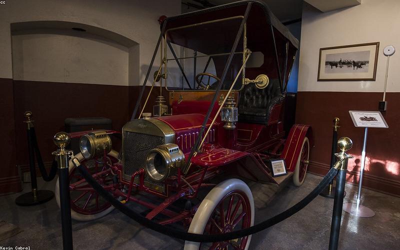 A sleek, wall-mounted hybrid solar inverter with digital display, indoors