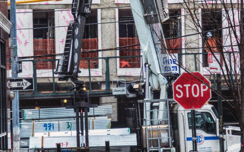 A trendy person walking with a solar-powered backpack, a charging cable visibly connected to their smartphone