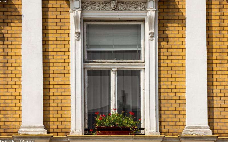 An architectural rendering of a modern glass skyscraper with transparent solar panels integrated into its windows