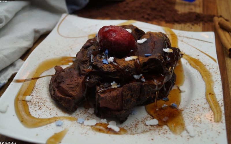 A close-up of golden, crispy loaded fries being pulled apart, showing the gooey cheese and layers of delicious toppings.