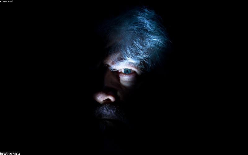 Group of young Pakistani entrepreneurs smiling and working on laptops, with a tech-themed background