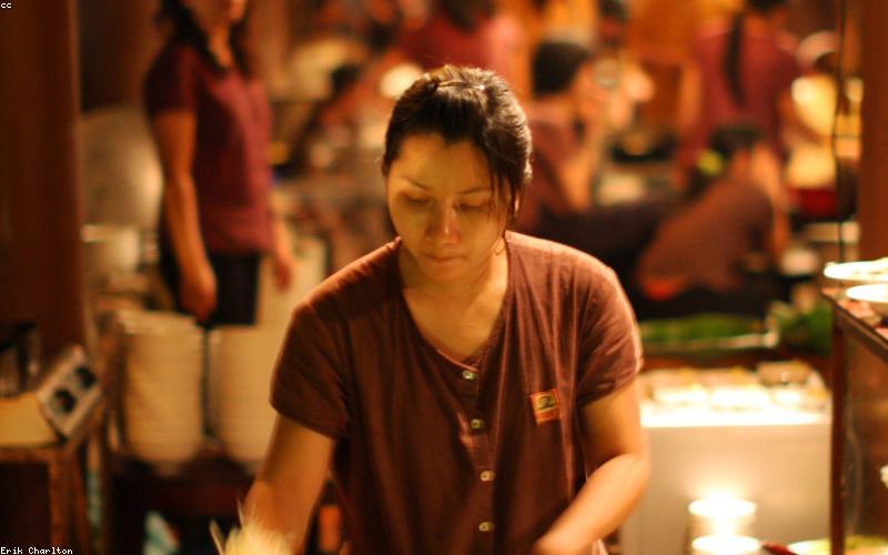 A flat lay of fresh, vibrant ingredients like tomatoes, green chilies, ginger, garlic, and chicken pieces, arranged neatly on a wooden board, ready for cooking.